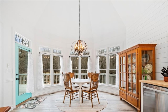 sunroom / solarium featuring an inviting chandelier, lofted ceiling, and beverage cooler