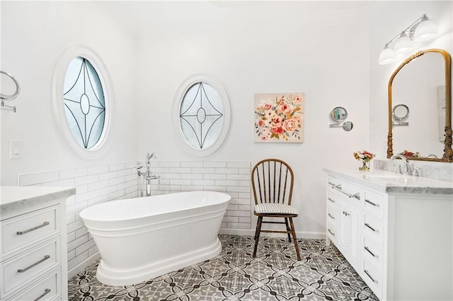 bathroom with tile patterned flooring, vanity, a tub, and tile walls