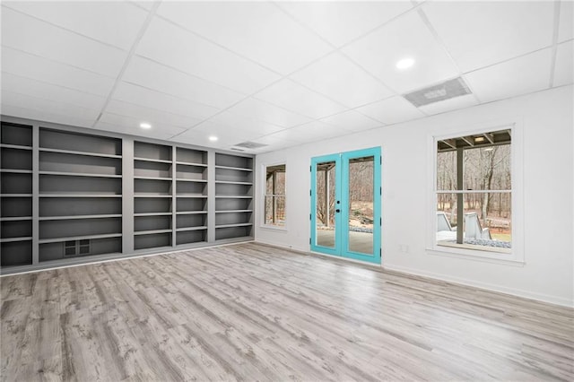 unfurnished room featuring french doors, a paneled ceiling, wood-type flooring, and built in shelves