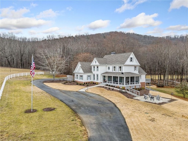 back of house featuring a lawn and a sunroom