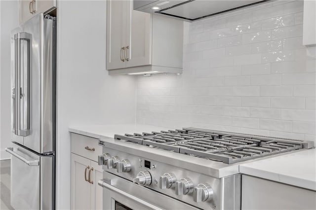 kitchen featuring high end appliances, backsplash, and ventilation hood