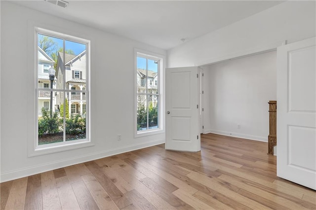 unfurnished room featuring plenty of natural light and light hardwood / wood-style floors