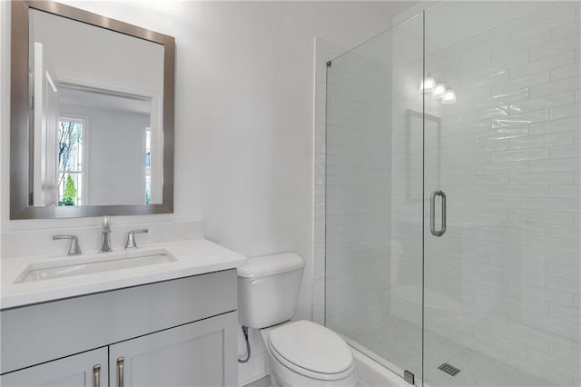 bathroom featuring walk in shower, vanity, and toilet