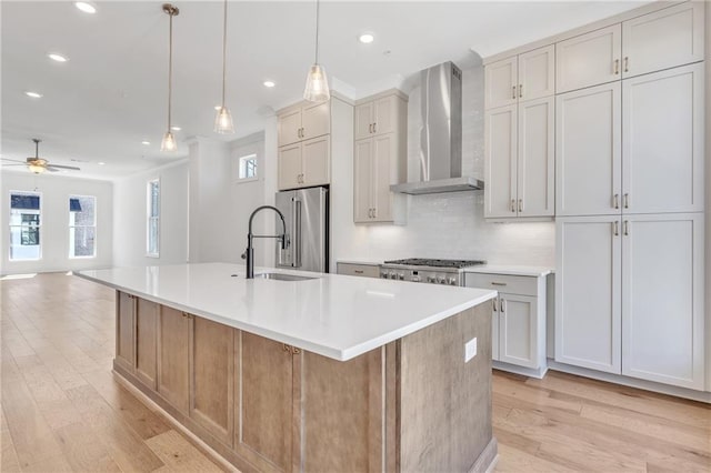 kitchen with backsplash, a spacious island, decorative light fixtures, high end refrigerator, and wall chimney exhaust hood