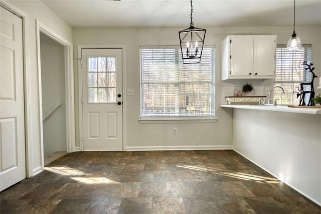 kitchen with white cabinets, a notable chandelier, sink, and hanging light fixtures