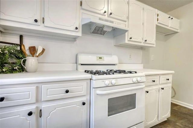 kitchen featuring dark hardwood / wood-style floors, white cabinetry, and gas range gas stove