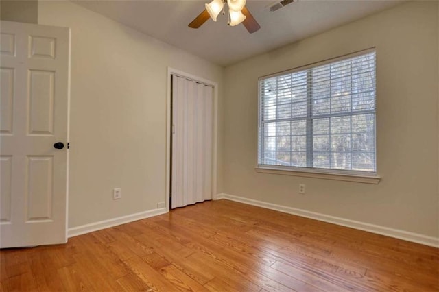 unfurnished bedroom with light wood-type flooring, a closet, and ceiling fan