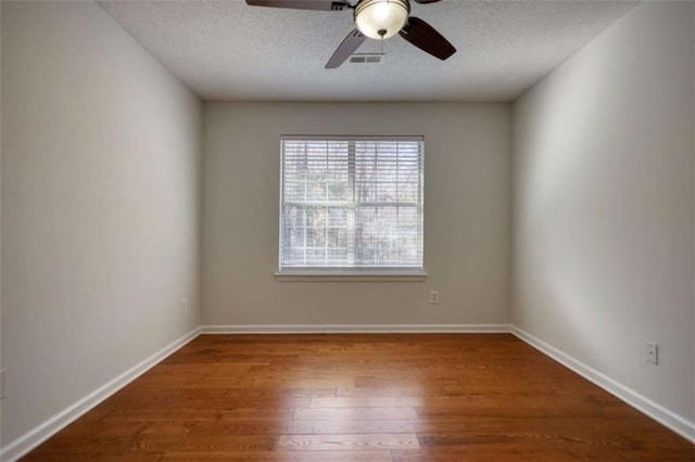 empty room with a textured ceiling, hardwood / wood-style flooring, and ceiling fan