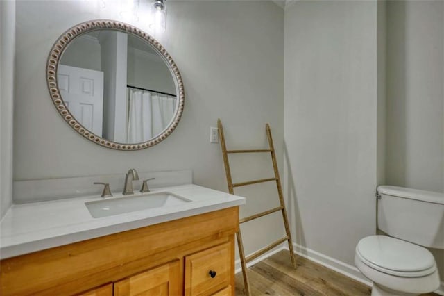 bathroom with wood-type flooring, vanity, and toilet