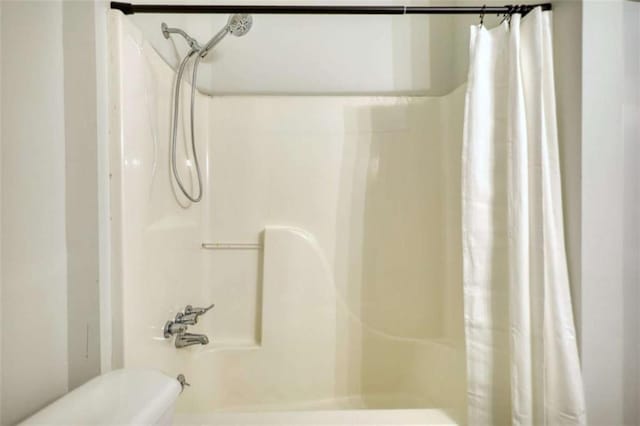 bathroom with shower / bath combo with shower curtain and toilet