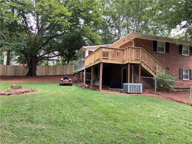 back of property featuring cooling unit, a yard, and a deck