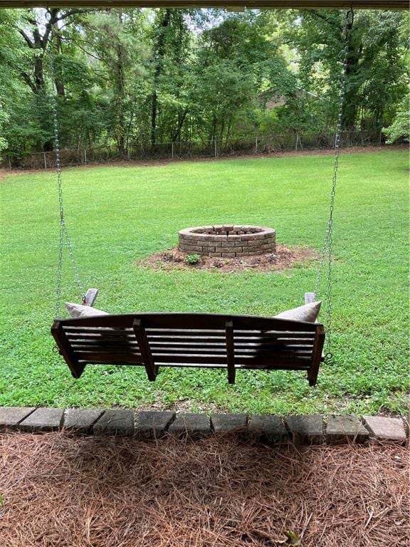 view of property's community with a fire pit and a lawn