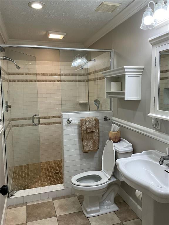 bathroom featuring ornamental molding, a shower with shower door, a textured ceiling, and toilet