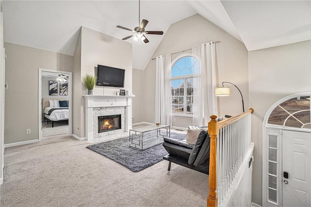 living room with baseboards, a ceiling fan, carpet flooring, high vaulted ceiling, and a high end fireplace