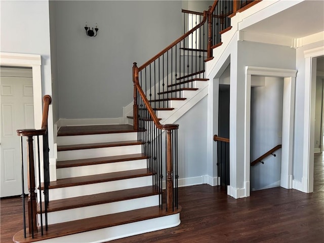 stairway with wood finished floors and baseboards