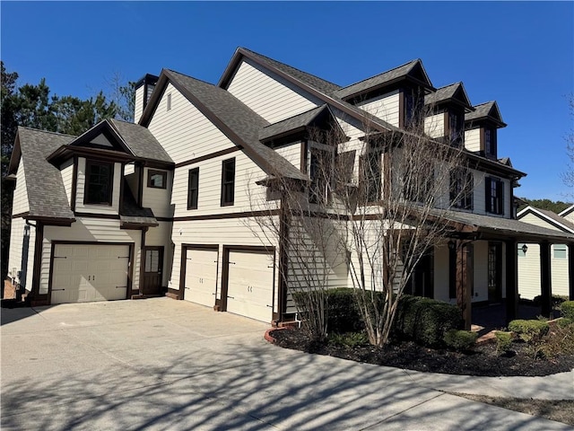 view of front of home featuring a garage, a porch, concrete driveway, and roof with shingles