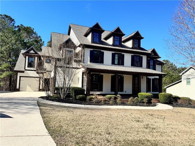 view of front of property featuring covered porch, driveway, and a garage