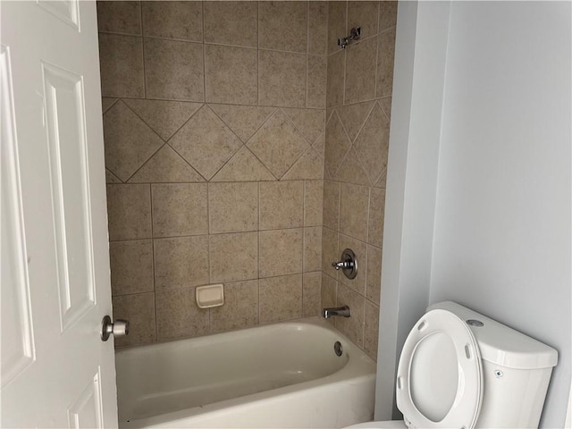 bathroom with washtub / shower combination and toilet