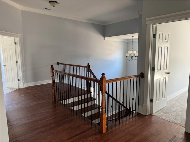 stairway featuring a chandelier, visible vents, baseboards, and wood finished floors