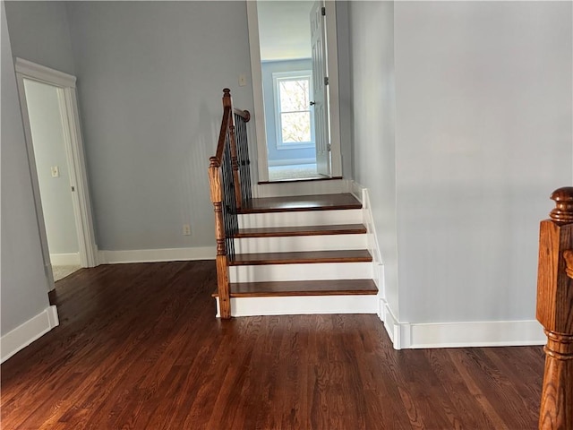 stairway featuring wood finished floors and baseboards