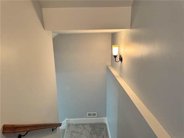 stairway with baseboards, visible vents, and carpet flooring