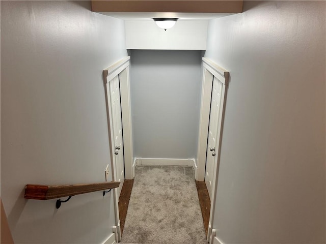 hallway with carpet floors and baseboards