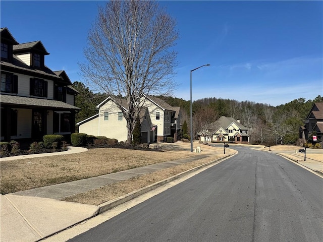 view of street with street lighting, a residential view, curbs, and sidewalks