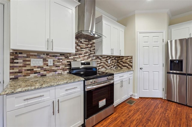 kitchen featuring stainless steel appliances, tasteful backsplash, wall chimney range hood, ornamental molding, and white cabinets