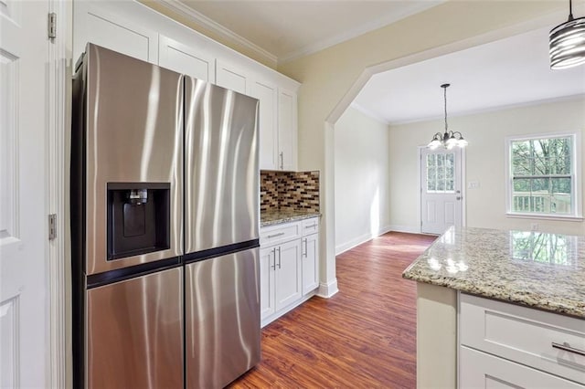 kitchen featuring decorative light fixtures, tasteful backsplash, stainless steel fridge with ice dispenser, ornamental molding, and white cabinets