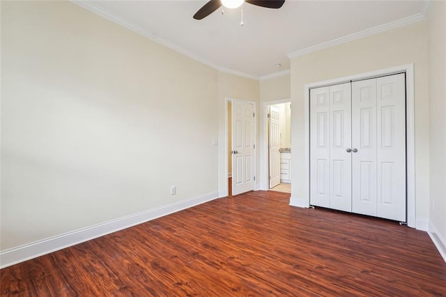 unfurnished bedroom featuring dark wood-type flooring, ceiling fan, ornamental molding, and a closet