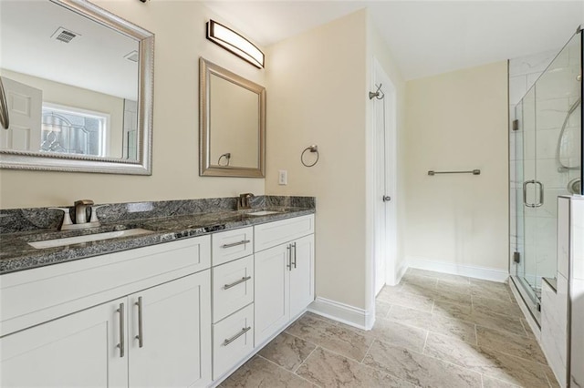 bathroom featuring a shower with shower door and vanity