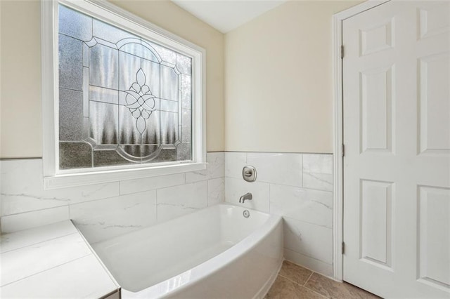 bathroom featuring tile walls, a tub, and tile patterned floors