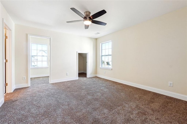 unfurnished bedroom featuring ceiling fan, a spacious closet, and carpet flooring