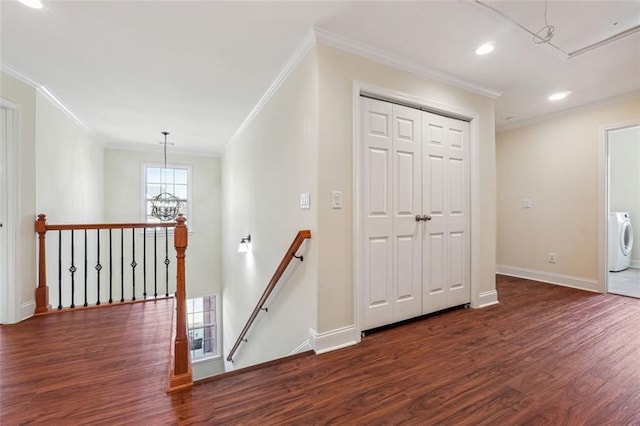 hallway with washer / clothes dryer, dark hardwood / wood-style floors, and ornamental molding