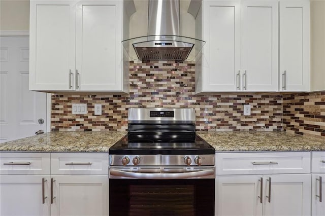 kitchen featuring backsplash, wall chimney range hood, and gas range