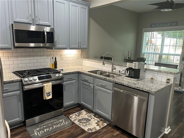 127 Spring Way Sq, Canton, GA 30114 - kitchen featuring stainless steel appliances, gray cabinetry, a peninsula, decorative backsplash, and dark wood-style floors