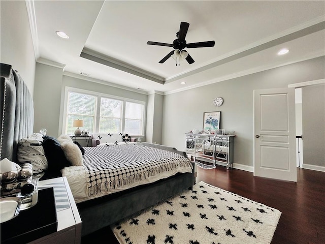 bedroom featuring recessed lighting, a raised ceiling, crown molding, and wood finished floors
