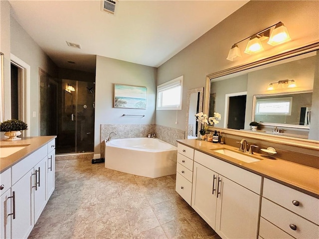bathroom with two vanities, a sink, a garden tub, and a stall shower