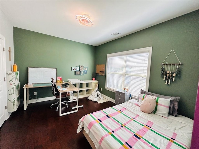 bedroom featuring baseboards, wood finished floors, and visible vents