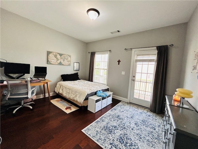 bedroom featuring baseboards, access to exterior, wood finished floors, and visible vents