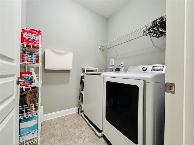 clothes washing area featuring washer and dryer, laundry area, and baseboards