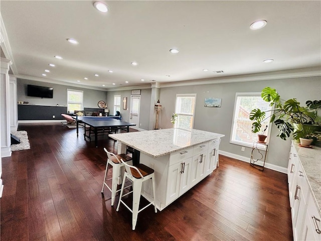 kitchen featuring ornate columns, ornamental molding, white cabinetry, and recessed lighting