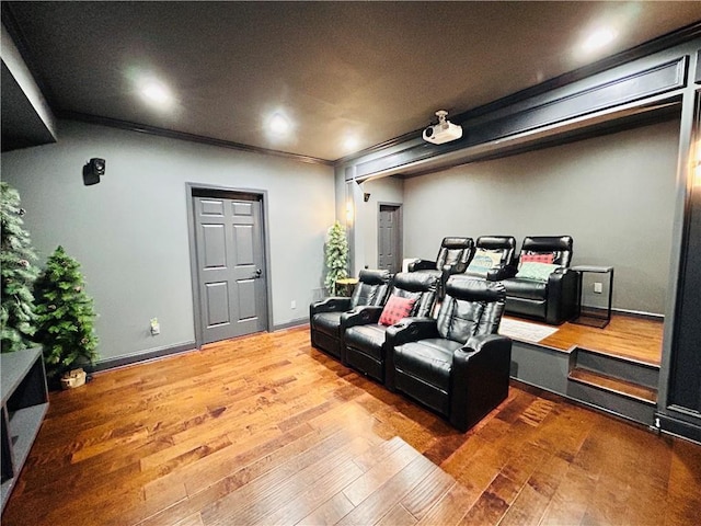 cinema with baseboards, ornamental molding, and wood-type flooring