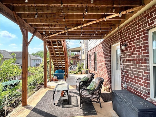 view of patio / terrace featuring fence, an outdoor living space, and stairway