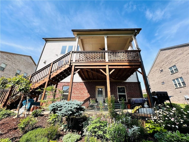 rear view of property with stairway, brick siding, and a deck