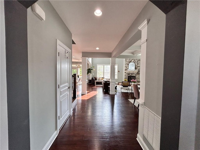 hall featuring ornate columns, recessed lighting, baseboards, and dark wood-type flooring