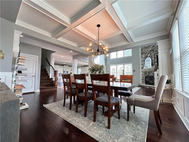 dining space with coffered ceiling, beam ceiling, and a fireplace