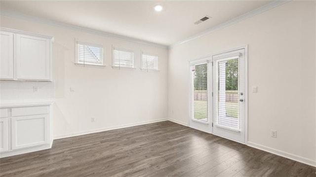989 Blue Juniper Cir, Loganville, GA 30052 - empty room featuring baseboards, visible vents, crown molding, and dark wood-style flooring