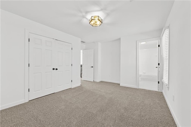 unfurnished bedroom with multiple windows, a closet, carpet floors, connected bathroom, and baseboards