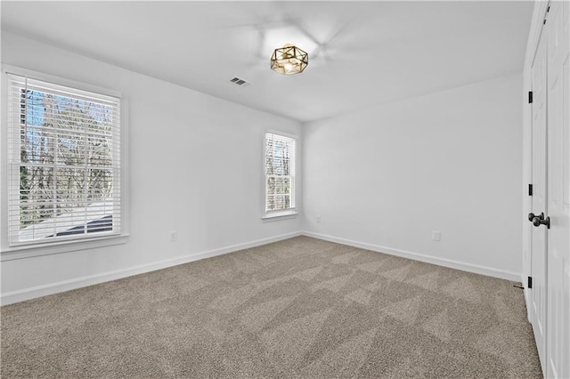 carpeted empty room with visible vents and baseboards